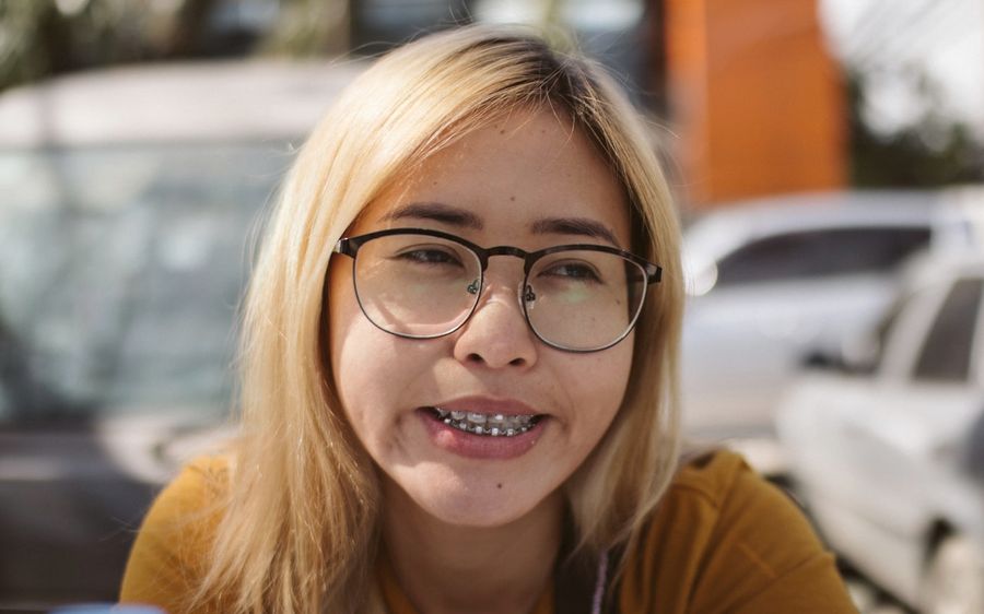 Jovem sorrindo com aparelho ortodôntico fixo