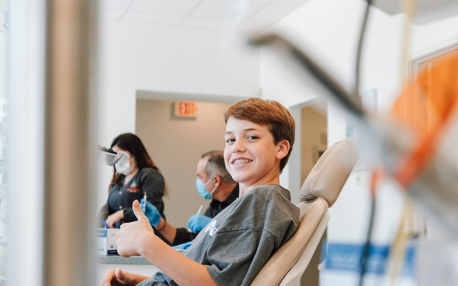 Menino sorrindo na cadeira do dentista